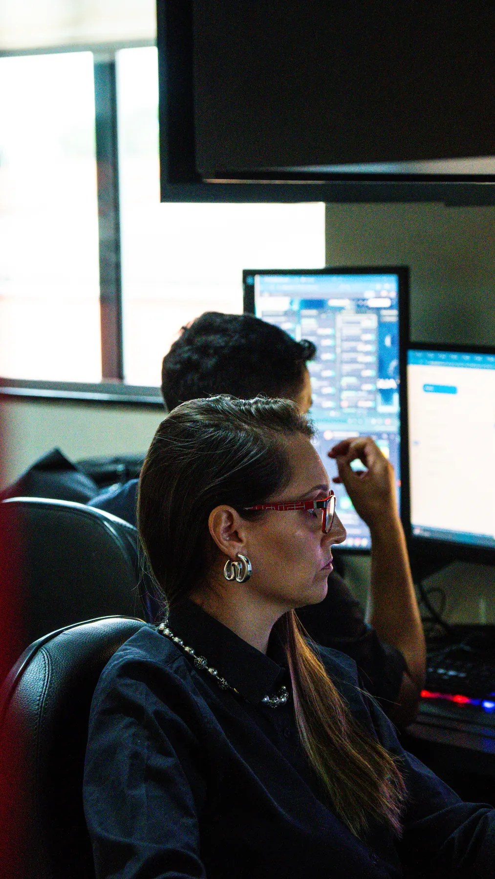 Dois colaboradores trabalhando em estações com múltiplos monitores no escritório da Salazar Digital.