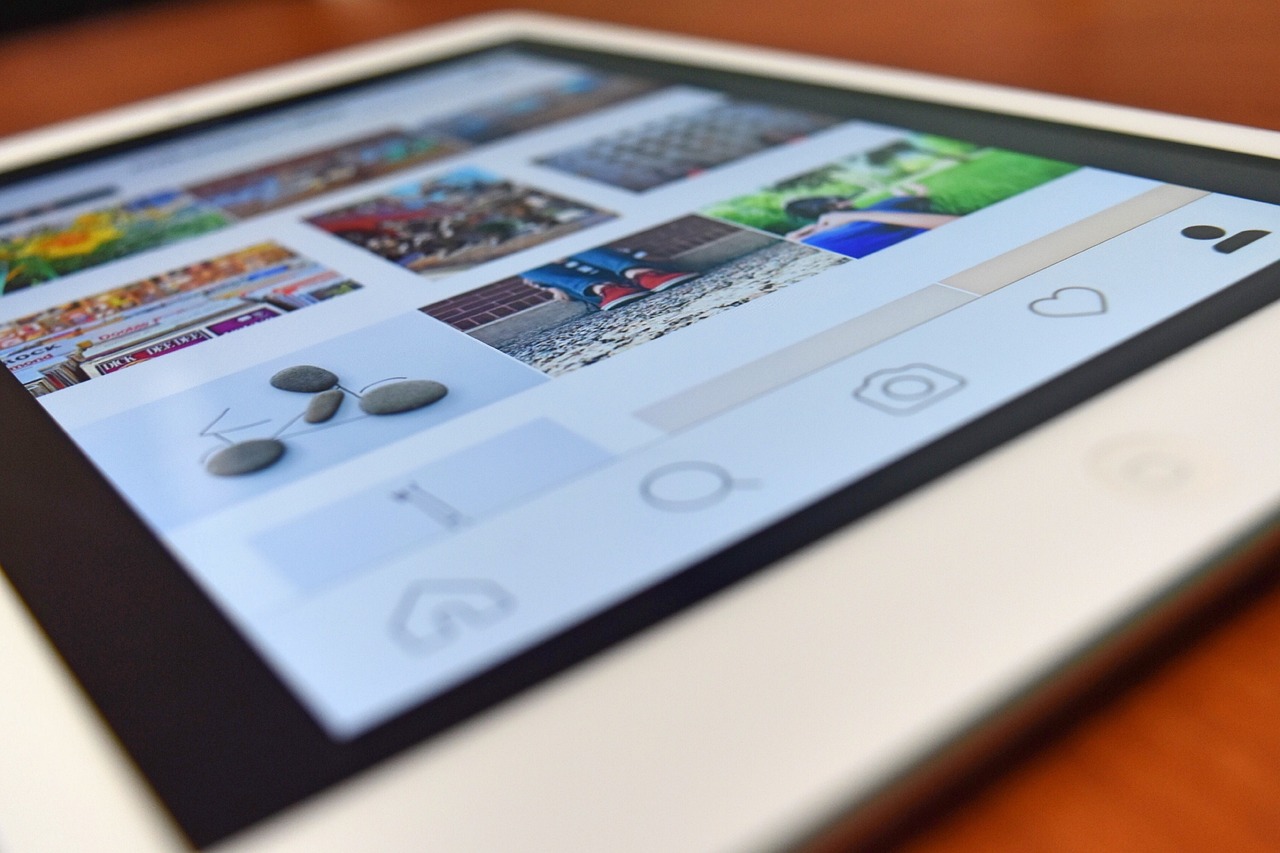  Close na navegação de feed com destaque para posts e Reels Virais na interface do Instagram em um tablet.